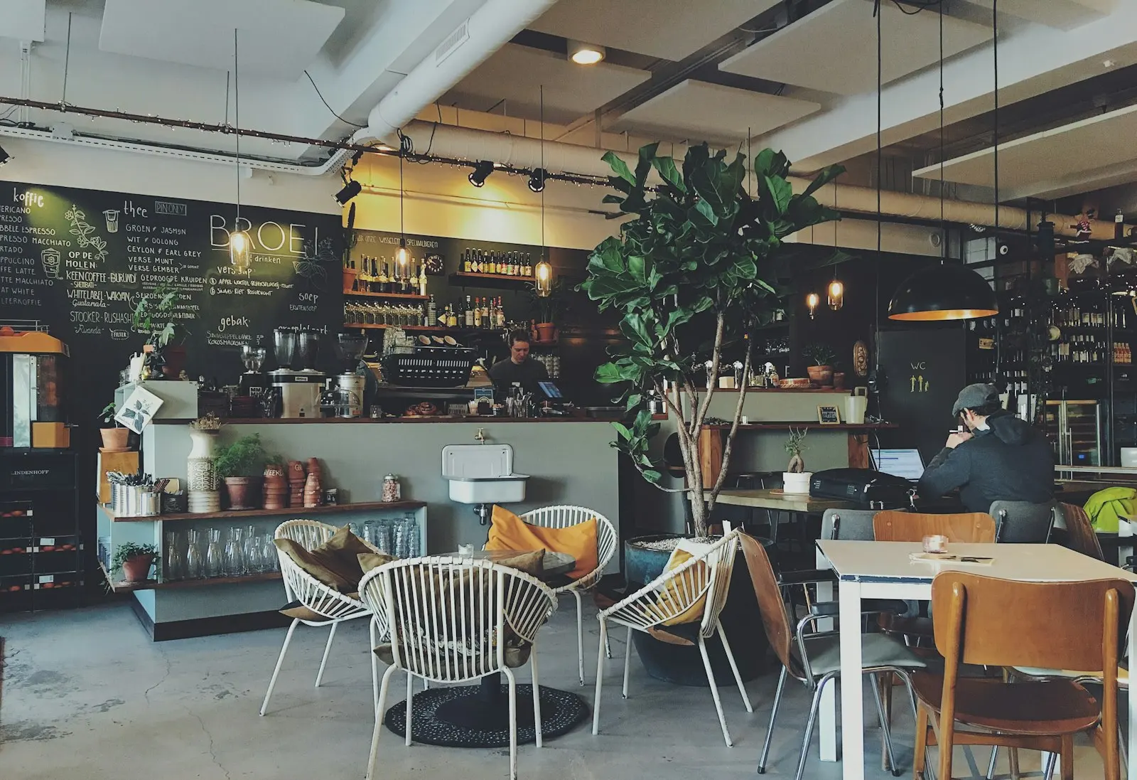 Cafe interior with plants and wooden tables