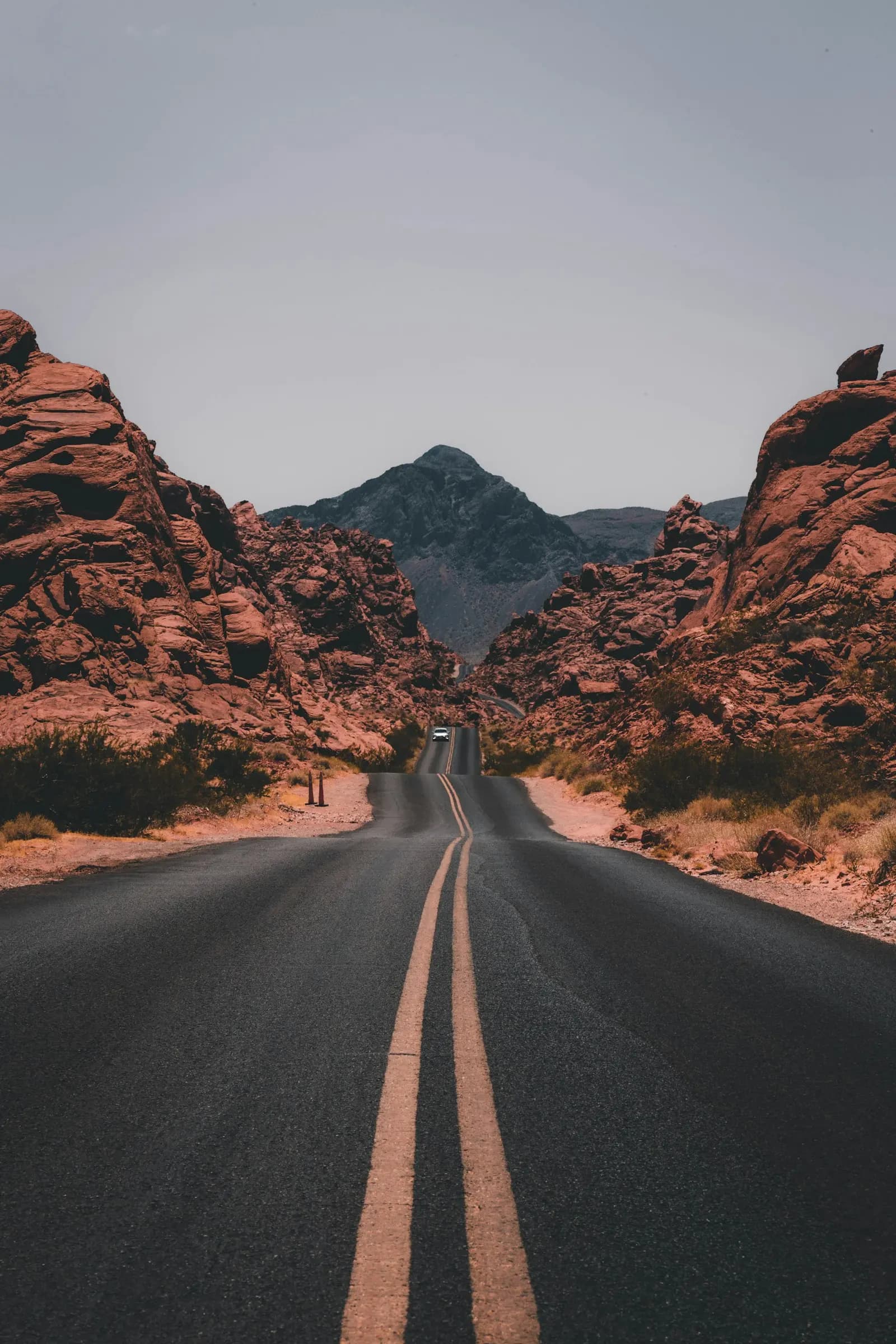 A desert road running between red rock formations
