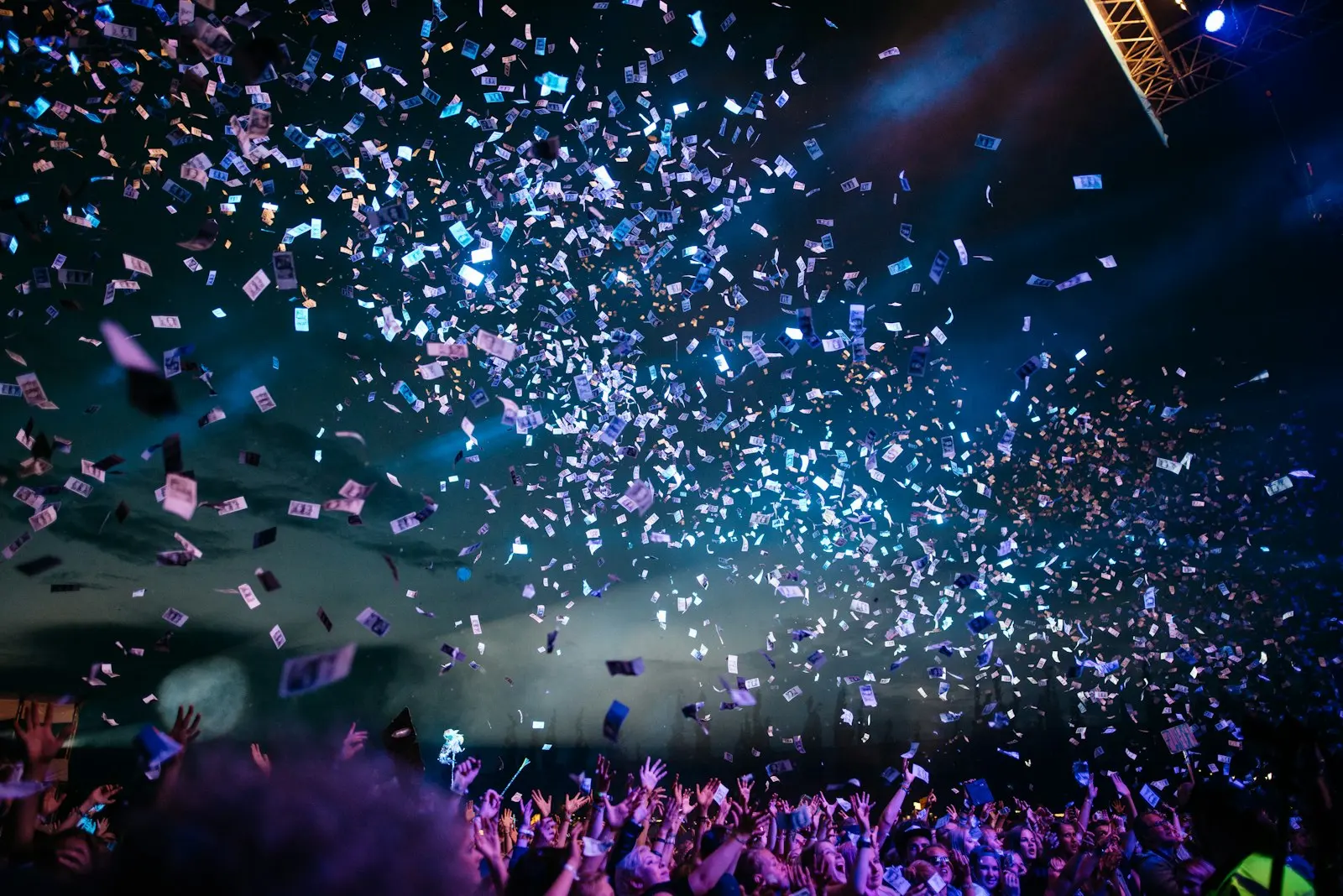 Confetti falling over a crowd in blue light