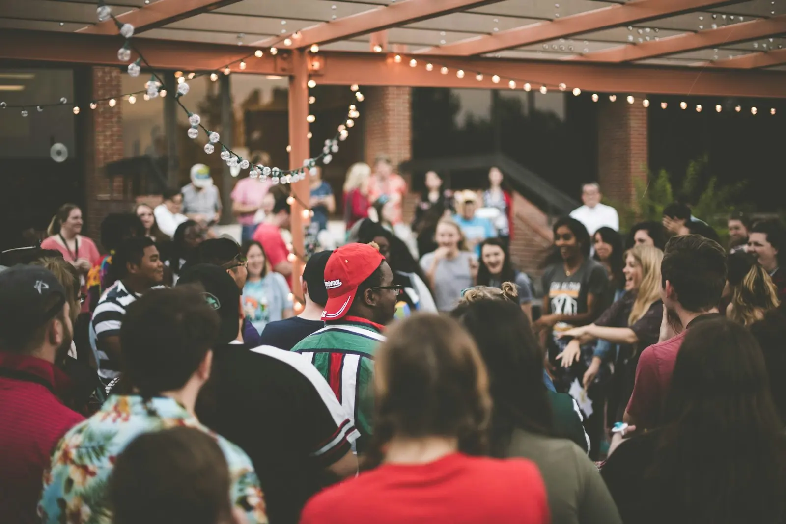 A crowd gathered outdoors under string lights in the evening