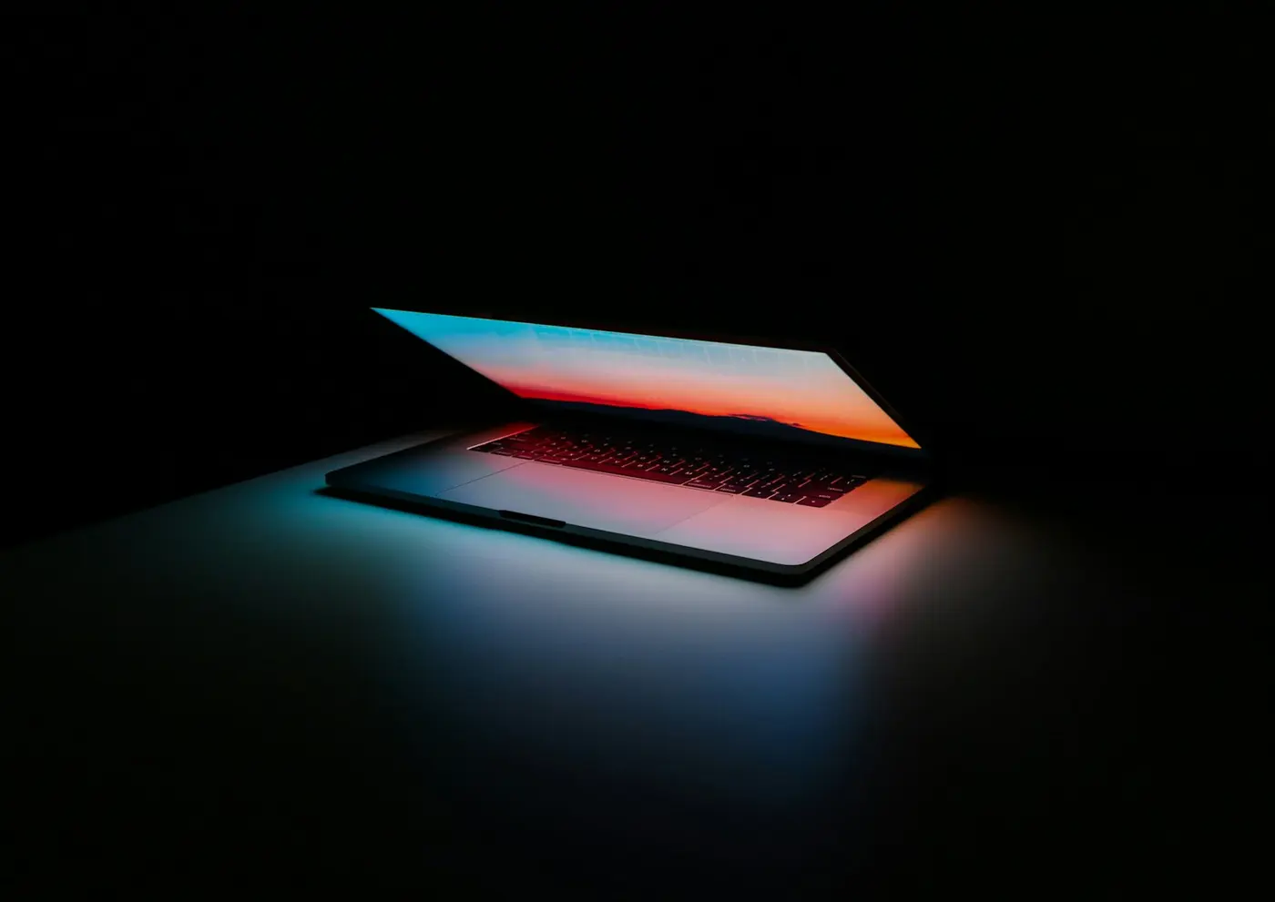 A dark laptop screen glowing in a dim room