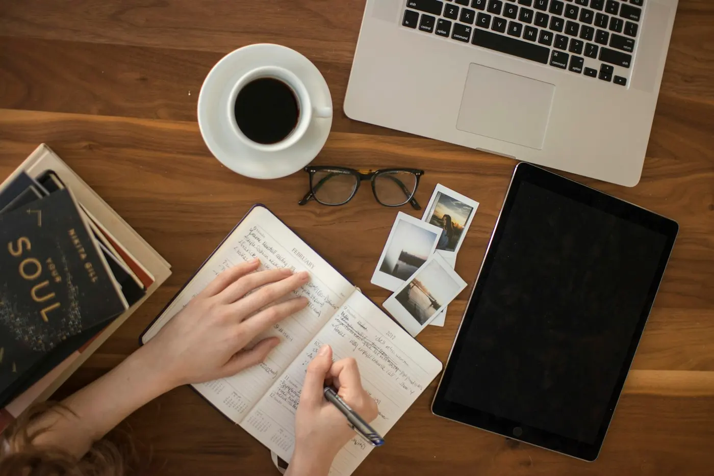 Top-down view of a desk with a notebook and a coffee